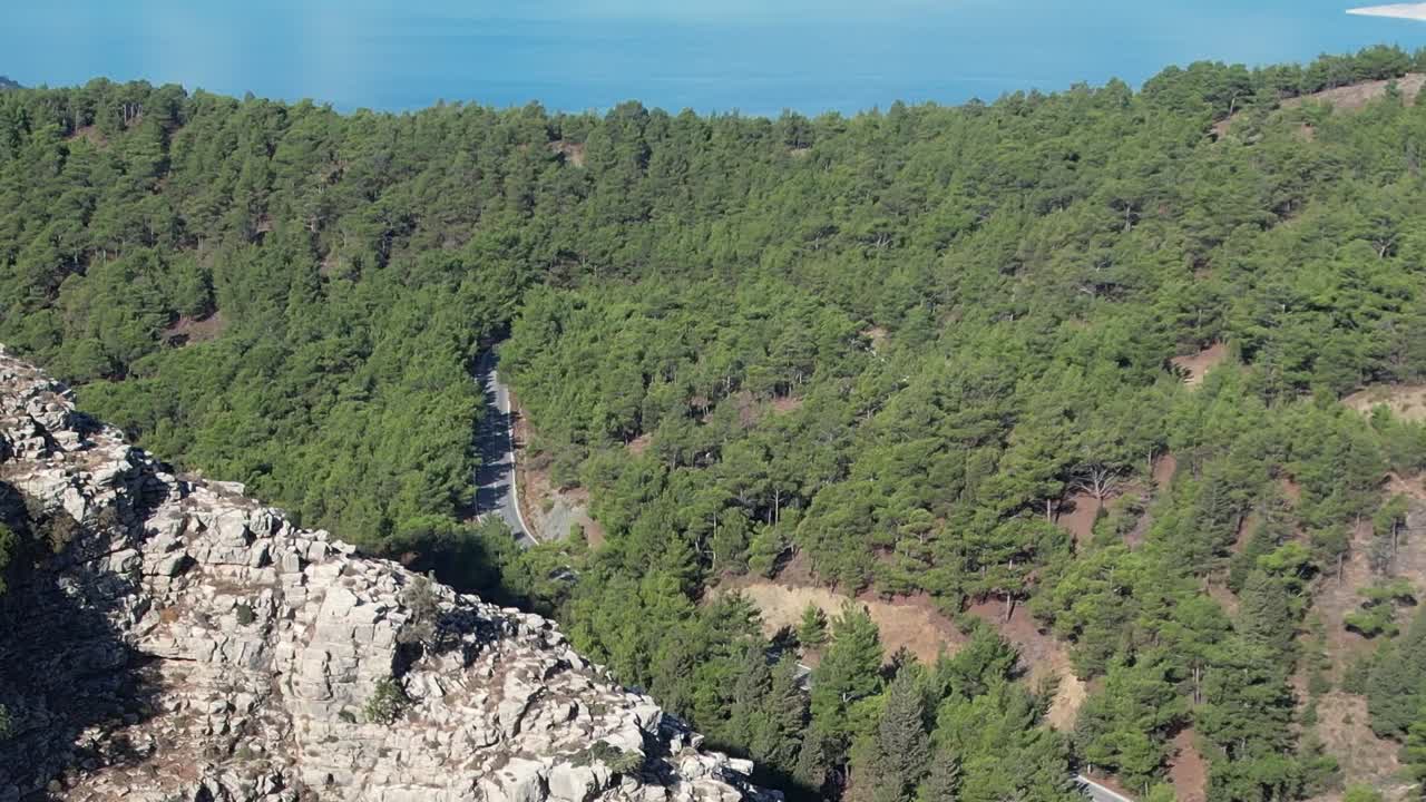 Aerial view of lush forests and rocky terrain along the coast in Greece