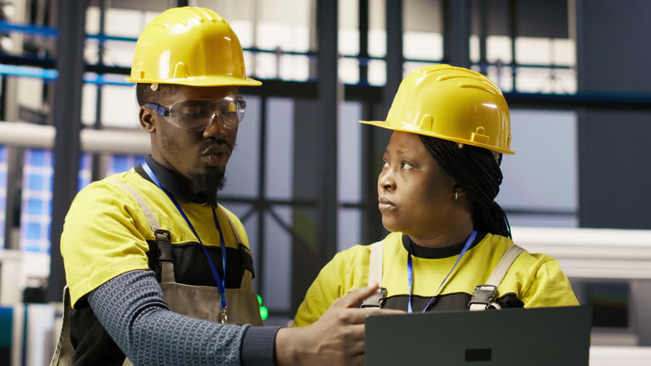 Vertical video Smart factory engineering team using laptop to calibrate high tech machinery