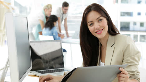 Mujer-Trabajando-En-Su-Escritorio-Mirando-La-Carpeta