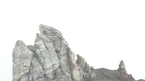 gran roca en la cima de la montaña rodeada de niebla espesa
