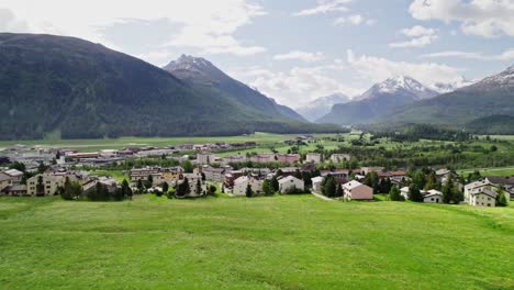 idyllic swiss town and captivating alpine peaks, aerial push in