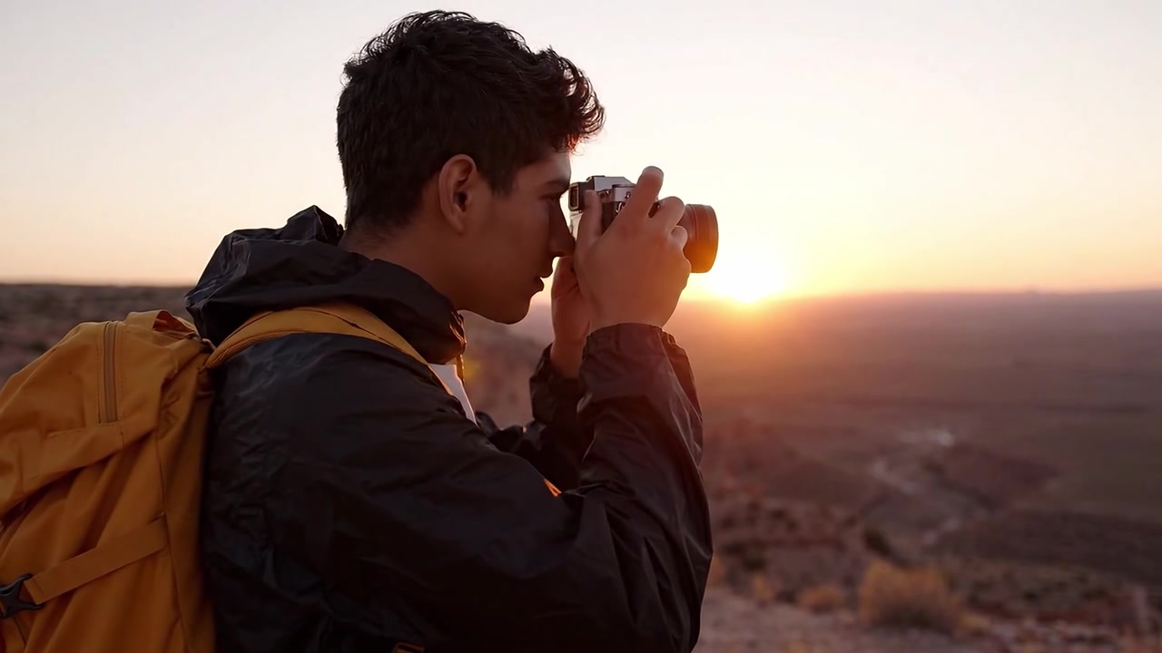 A Young Explorer Captures the Beauty of Sunrise Over a Desert Landscape with Camera in Hand, Embracing the Adventure of Nature and Photography