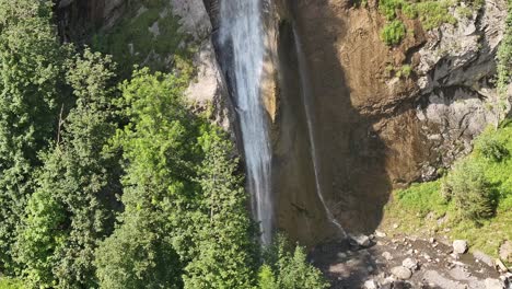 Vista-Aérea-De-Una-Cascada-Que-Cae-Sobre-El-Accidentado-Terreno-De-Klöntal-En-Glarus-Süd,-Suiza,-Capturando-El-Concepto-De-Belleza-Natural-Cruda-Y-Poder.