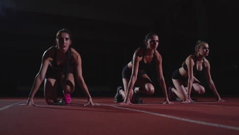 atletas femeninas calentándose en la pista de atletismo antes de una carrera. en cámara lenta