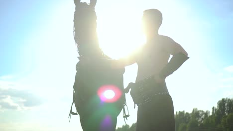 a man stands near a horse in a field 05