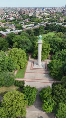 vertical drone footage side-tracking across the prison ship martyrs monument in fort greene park, brooklyn. captures the monument with surrounding park and city views.