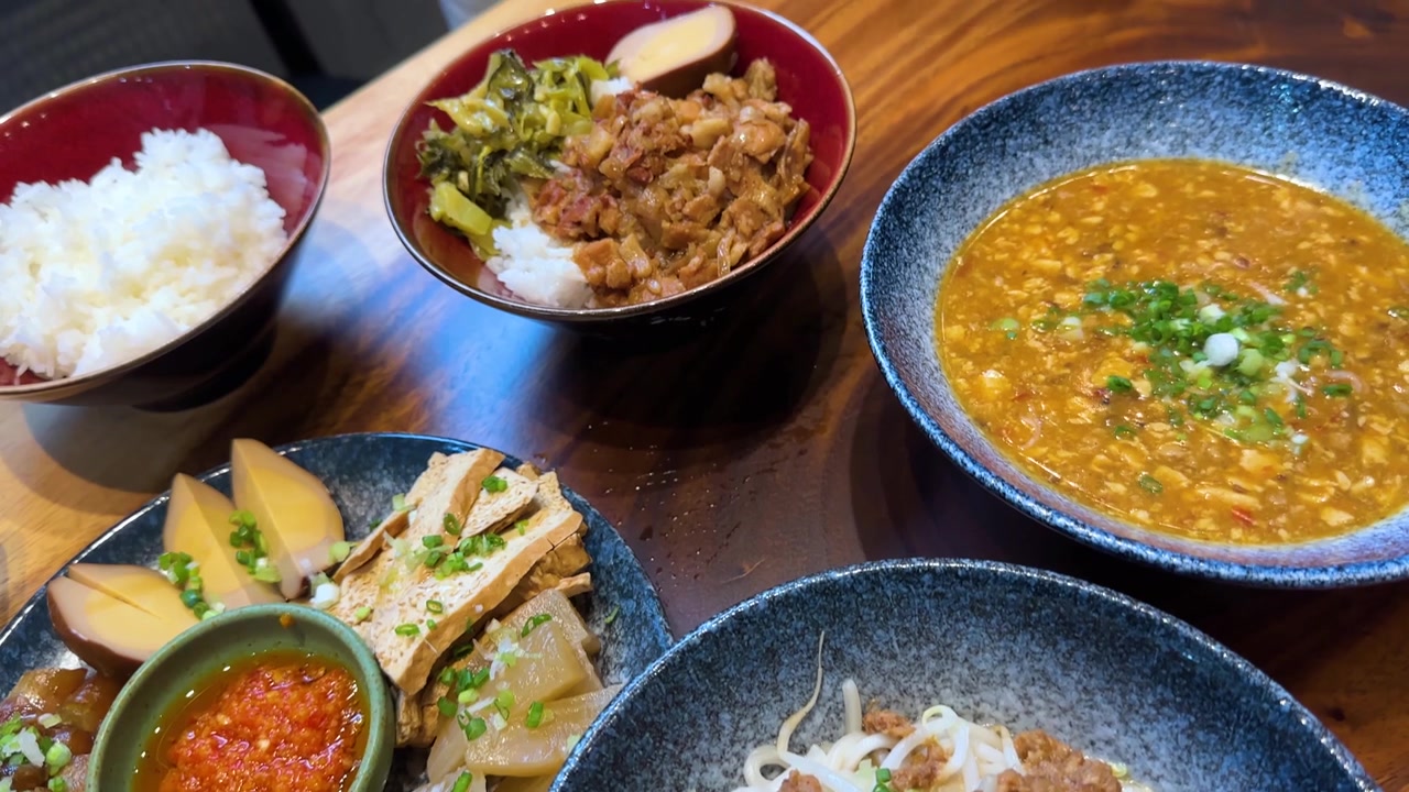 Pergerakan kamera dari atas melintasi berbagai hidangan Taiwan termasuk nasi babi rebus, mi, dan hidangan pembuka.
