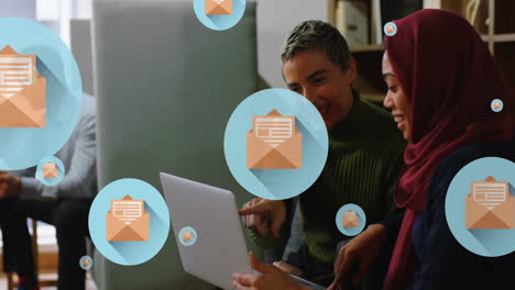 Animation-of-letter-in-open-envelope-icons,-diverse-female-coworkers-discussing-reports-on-laptop