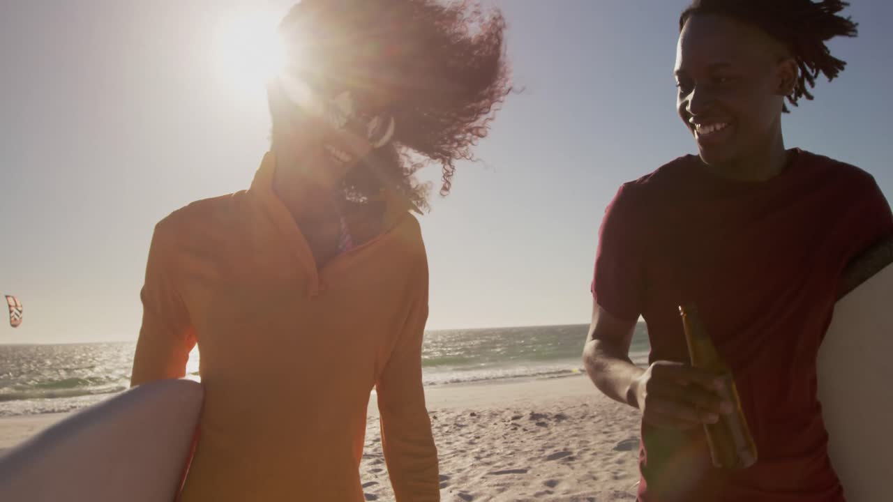 Couple walking together with surfboard on the beach 4k