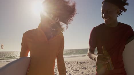pareja caminando juntos con una tabla de surf en la playa 4k