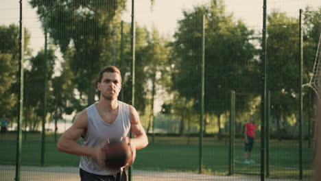 Fokussierter,-Gutaussehender-Basketballspieler,-Der-Den-Ball-Während-Einer-Trainingseinheit-Auf-Einem-Basketballplatz-Im-Freien-Empfängt,-Springt-Und-An-Seinen-Freund-Weitergibt