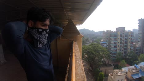 boy looking over the buildings and wearing mask new normal front shot