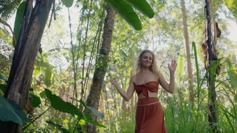 hermosa mujer bailando en el bosque disfrutando de la naturaleza bailando en la exuberante jungla tropical 4k