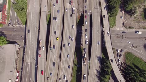 overhead aerial of commuters on city streets and travelers on freeway