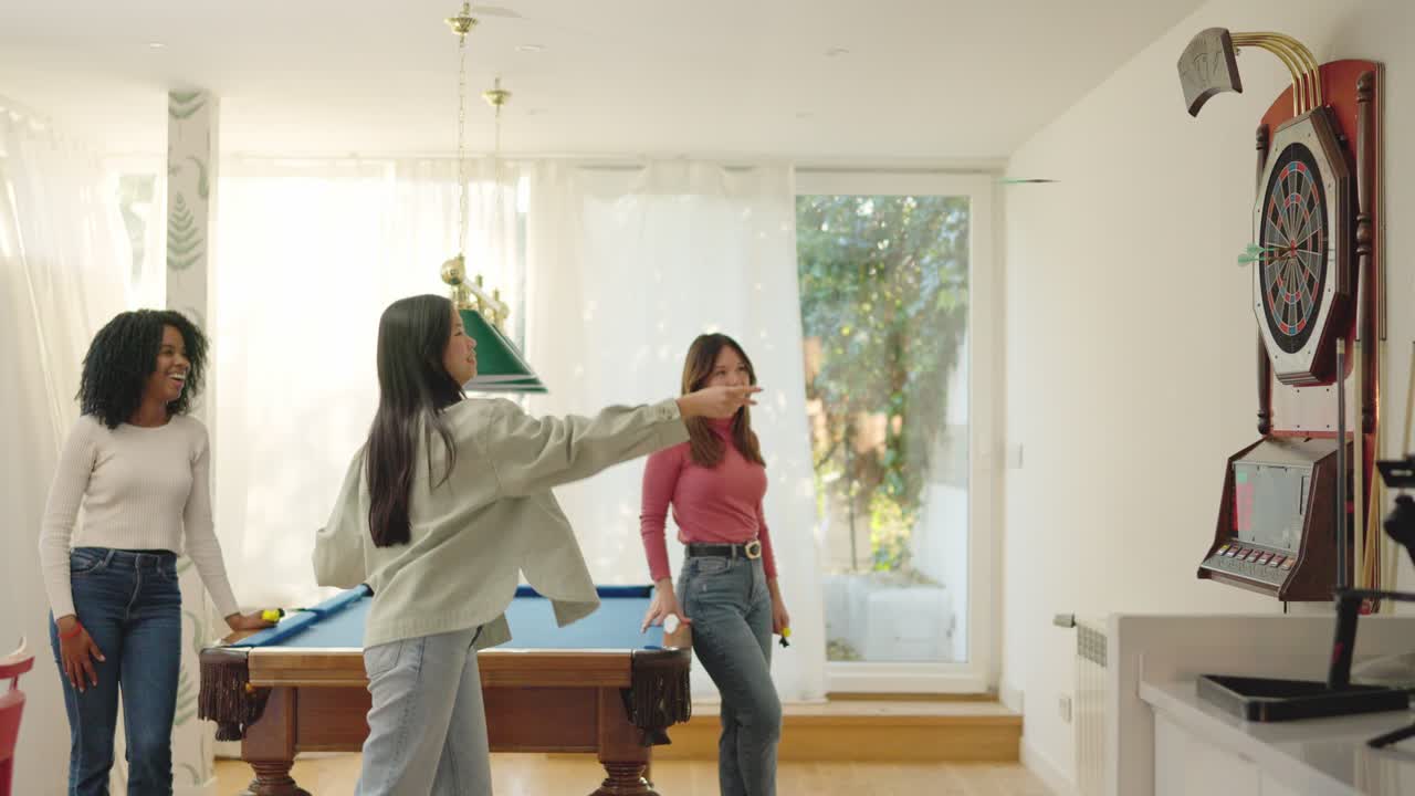 Friends congratulating a woman for hitting the bullseye in darts