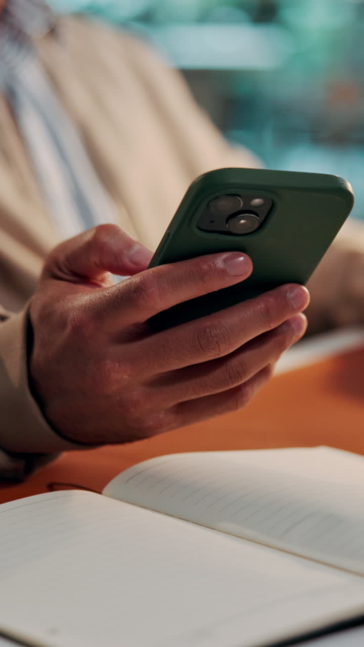 Close-up of Person's Hands Using Smartphone at Desk