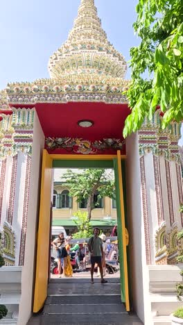 visitors entering wat pho through ornate gate
