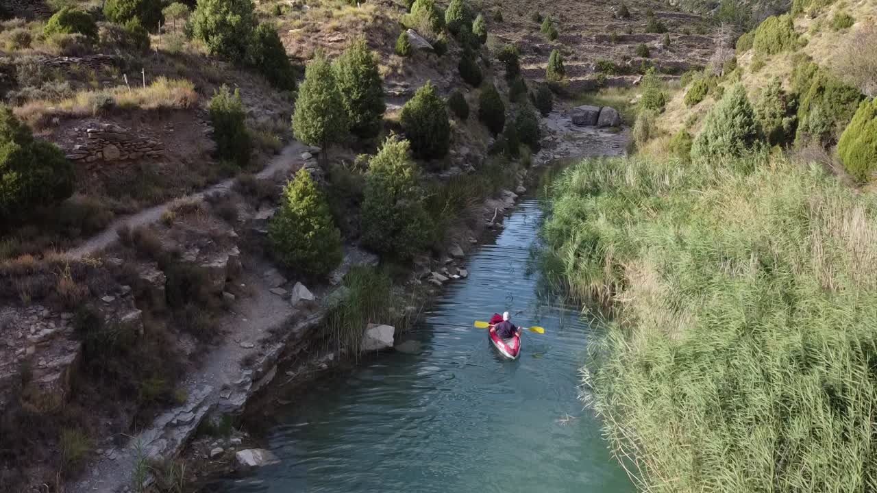 uomo in canoa che risale un fiume
