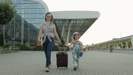 Mutter-Und-Tochter-Gehen-Vom-Flughafen.-Frau-Trägt-Koffertasche.-Kind-Und-Mutter-Nach-Dem-Urlaub