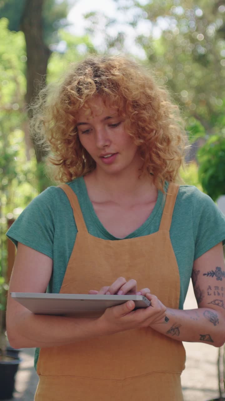 Woman using tablet in garden center