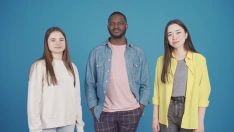 grupo de tres amigos modelos multiétnicos bailando mientras miran a la cámara, sacudiendo la cabeza al ritmo. diseño de moda.