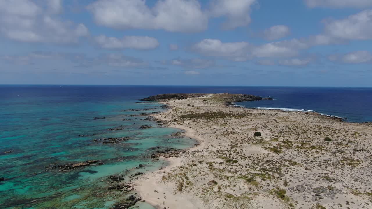 Rocky beaches of Elafonissi peninsula in Western Crete with lagoon to the left, Greece, Aerial flyover shot