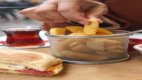 woman eating french fries and tea