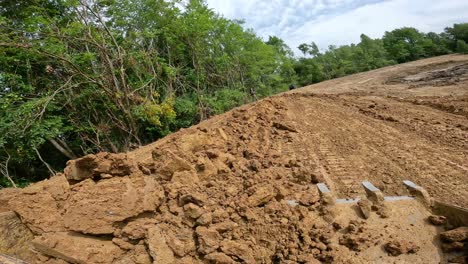 POV-while-operating-a-skid-steer-loader-to-move-piles-of-dirt-into-the-tree-line-at-a-land-development-site