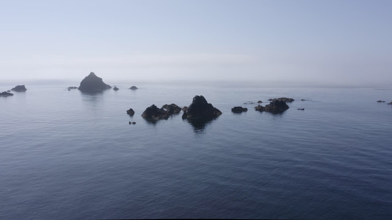 얕은 바다 물에 있는 작은 들쭉날쭉한 바위는 항해 위험이 있음