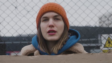 Close-Up-View-Of-Young-Female-Activist-Holding-A-Cardboard-Placard-And-Protesting-To-Save-The-Earth-During-A-Climate-Change-Protest-While-Looking-At-Camera-1