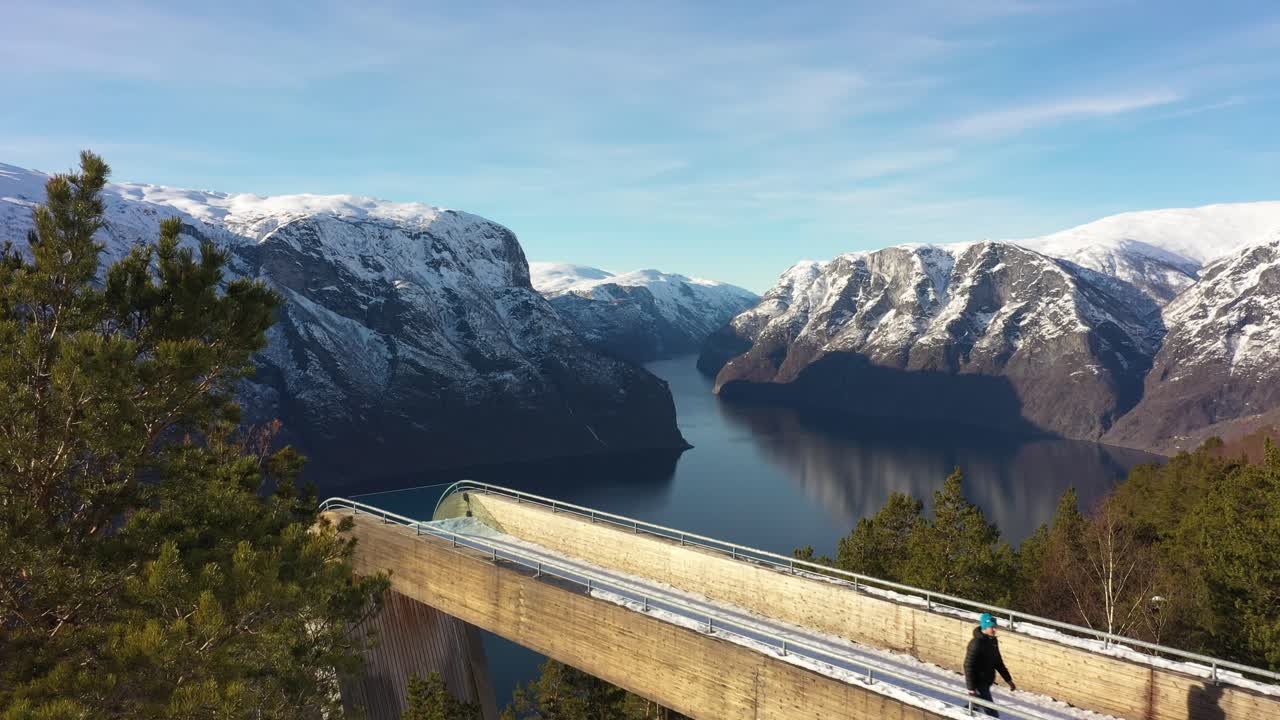 turista caminando de regreso a su camión después de visitar el mirador de stegastein en aurland - antena estática de atracción en un hermoso clima soleado