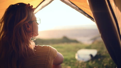 an attractive young woman relaxing inside a tent