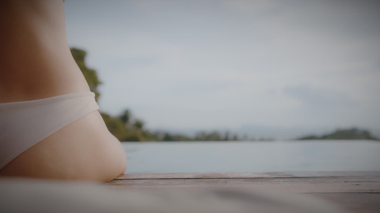 Woman relaxing by the pool with a drink