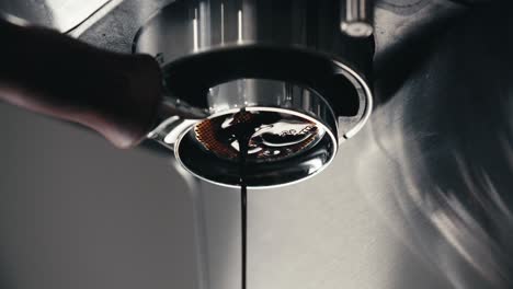 espresso machine pre-infusion pulling double shot extraction from bottomless naked portafilter with closeup of last fresh coffee drop dripping using professional equipment slow motion 4k