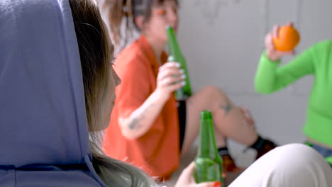 three young ladies toast with beers on a party