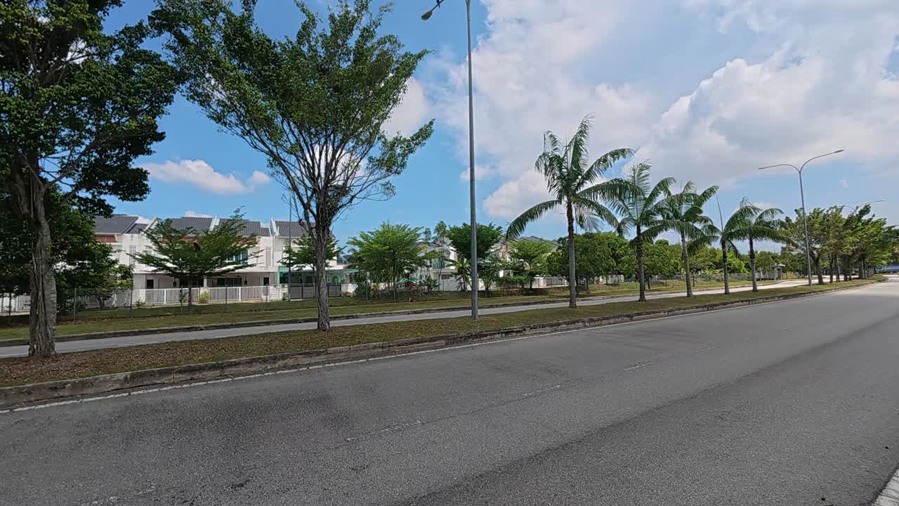 Decorative trees line the road median and roadside edges. They provide shade for both commuters and pedestrians using the area. These trees also function as a natural safety barrier during accidents
