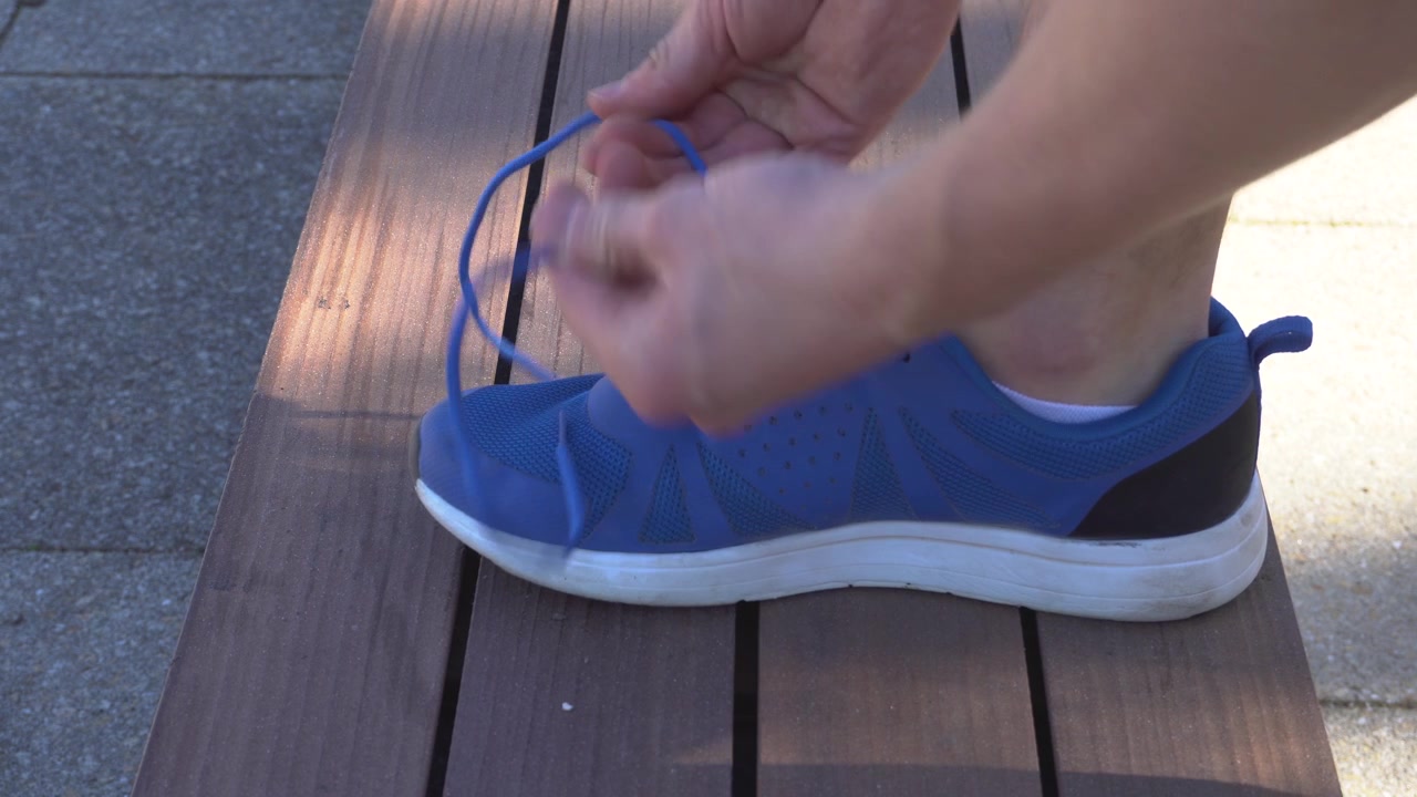 Un corridore si sta allacciando le scarpe