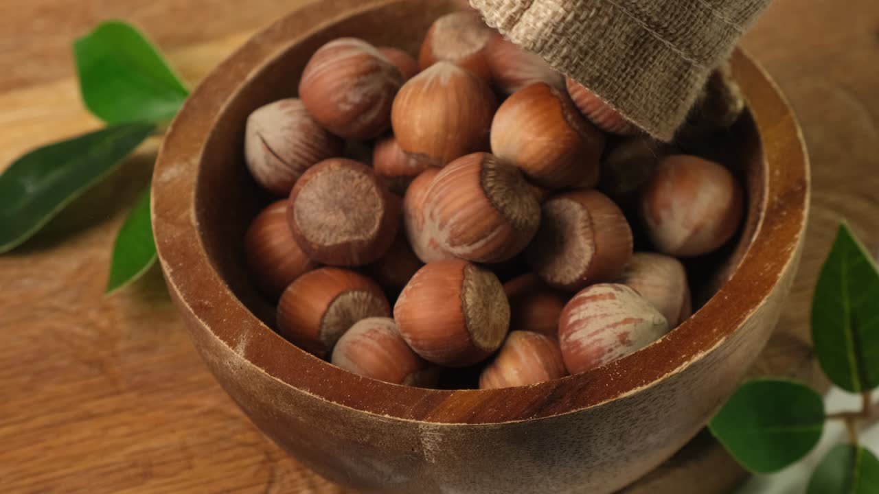 Le nocciole vengono versate in una ciotola di legno marrone