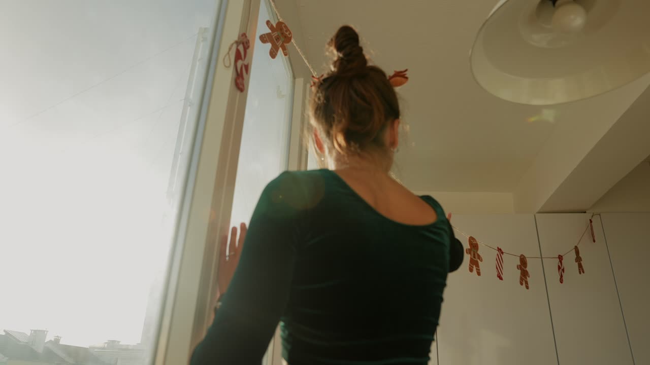 Donna che decora la finestra con omini di pan di zenzero per le feste