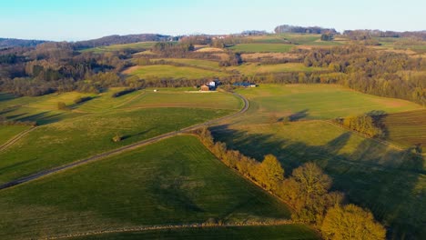 sunset glow on rolling countryside and farmhouse