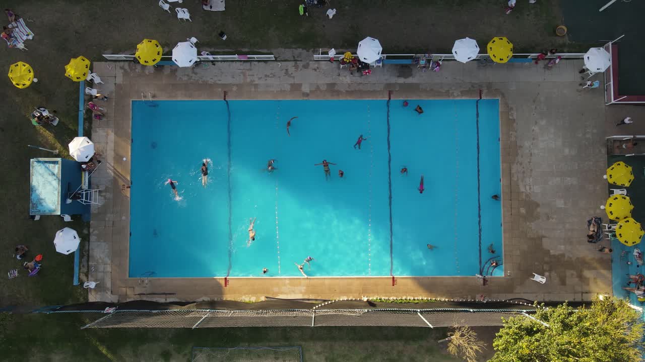 Pessoas e turistas se divertindo dentro da piscina durante o verão - vista aérea de cima.