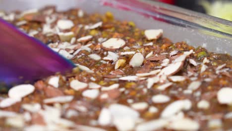 closeup of sweet caramel banana cake topped with almond nuts being sliced