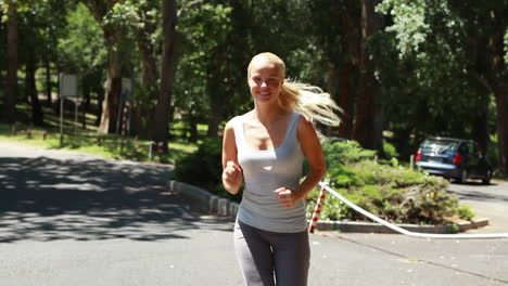 woman jogging down the street as a car drives behind her