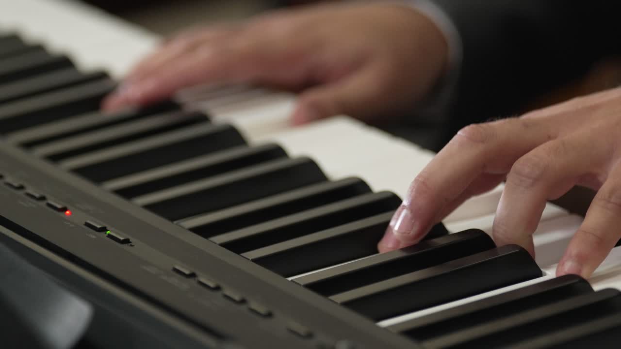 cerca de las manos tocando un teclado de piano digital durante una actuación