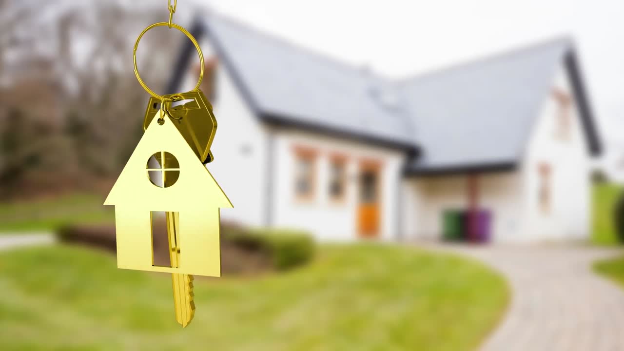 Chiavi di casa e telecomando chiave appese con una casa sullo sfondo