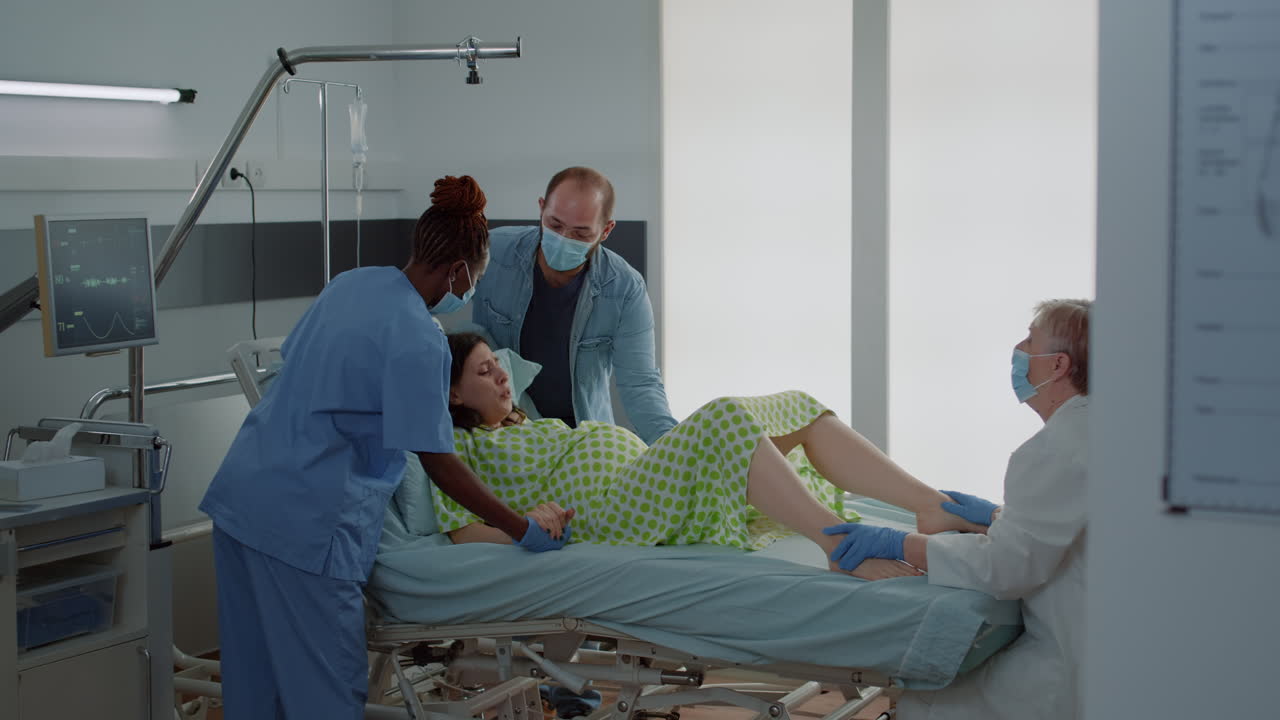 Pregnant woman giving birth in hospital ward bed