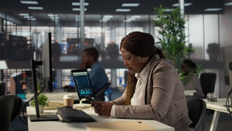 businesswoman working on computer and smartphone in modern office