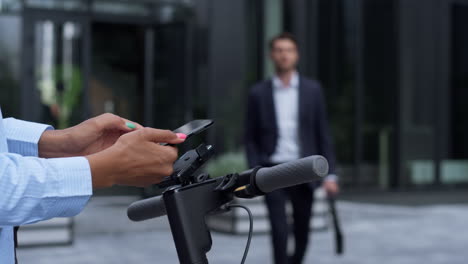 Frau-Mietet-Elektroroller-Im-Geschäftsviertel,-Nahaufnahme.-Mobilität-In-Der-Stadt.