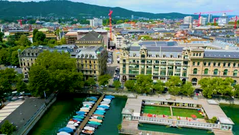 4k drone video of commuter trains on the quaibrücke bridge over the limmat river in downtown zurich, switzerland