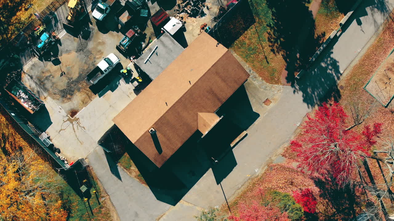 4K Drone Footage junk cars and mowers and the colors of fall, big red and orange leaves as far as the eye can see from a  birds eye-view